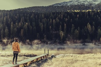 Young woman at Lake Staz near Sankt Moritz in the Engadine in Switzerland. Morning atmosphere with