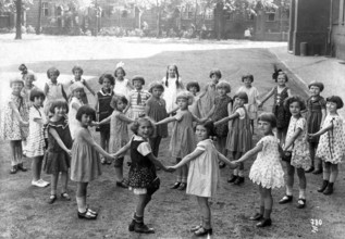 25 children playing, 1920, Several young girls holding hands in a schoolyard, Historical photo