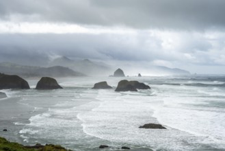 A rugged coastal landscape with rocks in the sea and a cloudy sky, Indian Beach, Oregon, USA, North
