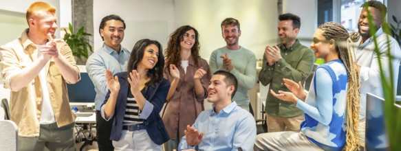 Happy colleagues clapping, celebrating a successful project or good news in a modern office
