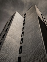 A striking building features unique geometric shapes and intricate brickwork, towering high against