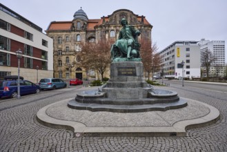 Monument to Otto von Guericke, pavement made of cobblestones, lantern, parking lane with vehicles,