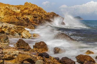 Rugged rocks and foaming spray on Topinetti beach, near Rio Marina, Elba Island, Tuscan Archipelago