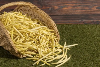 A basket filled with yellow beans on grass