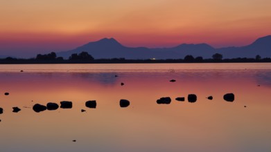 Dusk at the lake with dramatic sky and mountain silhouettes, salt lake, Tigaki, nature reserve,