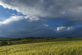 Dramatic cloudy sky with approaching storm and last rays of sunshine, Frankenhain, dark cloud wall,