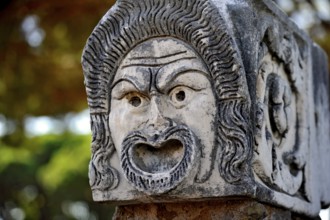 Ancient stone sculpture, stone carving of a mask, Roman theatre, ancient port city of Rome,