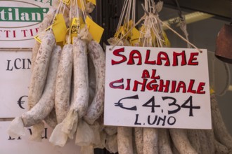 Italian market stall with wild boar salami and price tag, Tuscany, Italy
