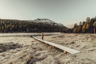 Young woman at Lake Staz near Sankt Moritz in the Engadine in Switzerland. Morning atmosphere with