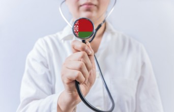 Female doctor holding stethoscope with Belarus flag. National health system of Belarus