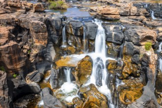 Waterfall on orange-coloured rock cliffs, long exposure, Blyde River, Bourke's Luck Potholes,