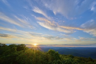 Sunset over green forests, the sky tinted in blue and orange, Katzenbuckel, Waldbrunn,