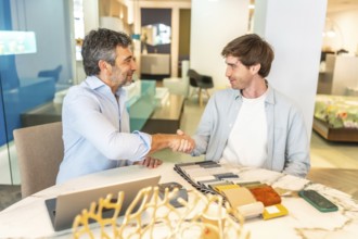 Interior designer shaking hands with a client in a furniture store showroom after choosing