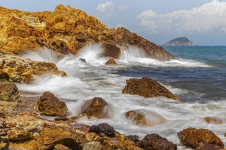 Rugged rocks and foaming spray on Topinetti beach, near Rio Marina, Elba Island, Tuscan Archipelago