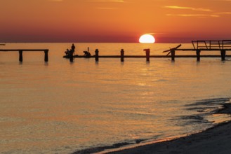 Sunset behind dilapidated fishing pier damaged by hurricanes on the Mississippi Gulf Coast in Long