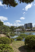 Shukkei-en with green plants and Takuei-chi pond in spring, historical Japanese strolling garden,