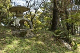 Toro stone lantern in Shukkei-en, historical Japanese strolling garden, Japanese garden, green