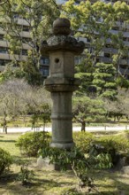 Toro stone lantern in Shukkei-en, historical Japanese strolling garden, Japanese garden, green