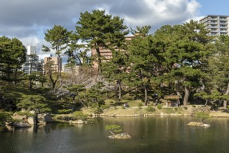 Shukkei-en with Sekisui-gan stone formation and Takuei-chi pond in spring, historical Japanese