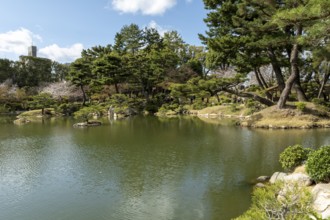 Shukkei-en with Sekisui-gan stone formation and Takuei-chi pond in spring, historical Japanese