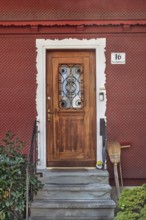 Red wooden shingle façade with wooden front door, Dornbirn, Vorarlberg, Austria
