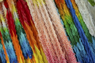 Chains of colourful origami cranes made of paper as a sign of peace in the Peace Park, close-up,