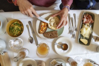 Breakfast table with various dishes served on a plate by someone with cutlery, Lower Austria