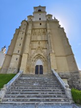 Gothic church with imposing stone façade and staircase under a clear sky, Pöllau Styria Austria