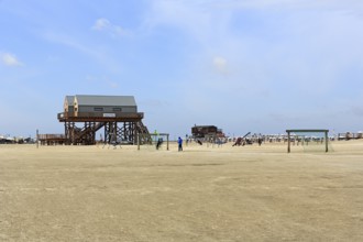 Pile dwellings, toilet block on the beach, beach chairs, football goal on the horizon, Sankt