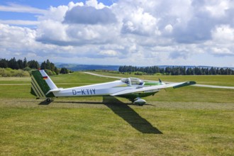 Motor glider of the type Scheibe SF.25C Falke standing on Wasserkuppe airfield, in the background