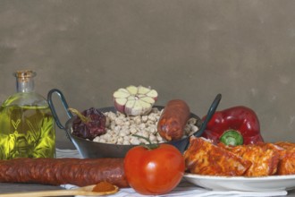 Raw chickpeas in a casserole with the ingredients to make the stew