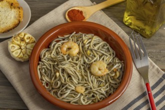 Gulas with garlic prawns in earthenware casserole dish