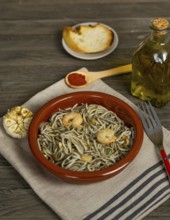 Gulas with garlic prawns in earthenware casserole dish
