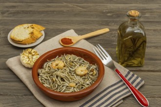 Gulas with garlic prawns in earthenware casserole dish