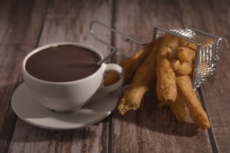 Cup of hot chocolate with freshly made churros on wooden background typical spanish breakfast on