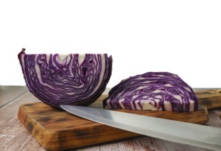 Close-up of a red cabbage or purple cabbage cut with a knife on a wooden board