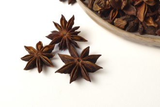 Close-up of star anise illicium verum in a wooden spoon isolated on white background and copy space