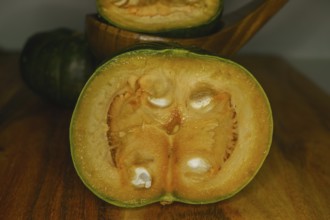 Green pumpkins cut in half on wood and white background