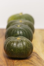 Green pumpkins cut in half on wood and white background