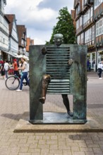 Bronze sculpture, A man pushes through the gate, French artist Joan Ipoustéguy, pedestrian