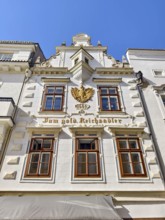 Historic building façade with golden eagle decoration under a blue sky Bürgerhaus Zum goldenen