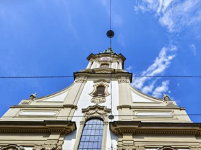 Baroque church façade rises majestically into the blue sky with delicate clouds Herz Jesu Kirche