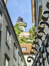 View through narrow old town street to a historic tower, flanked by old buildings Graz Clock Tower