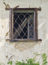 Old window with wooden lattice in a crumbling wall, part of an abandoned building Styria Austria