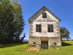 Old building with shutters and grass area surrounded by trees Styria Austria