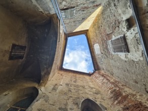 View through an open roof of blue sky with clouds surrounded by old stone walls Riegersburgs Styria