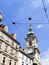 Detailed church tower rises above bourgeois buildings with a clear sky Herz Jesu Kirche Graz Styria