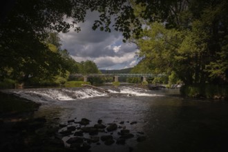 A river with a waterfall and bridge amidst trees and dark clouds Hardegg Weinviertel Lower Austria