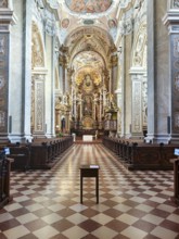 Opulently furnished nave with ornate Baroque ceiling decorations and symmetrical structure,