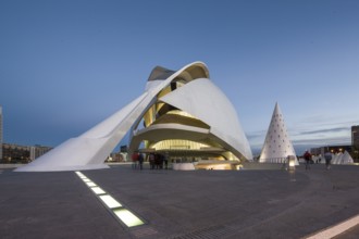 White modern building illuminated at dusk with people in the foreground Opera